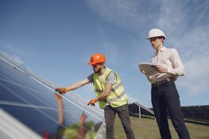 Solar panel installers inspecting ground mounted solar panels