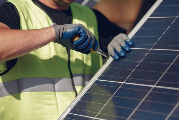 Close up of installer fastening solar panel