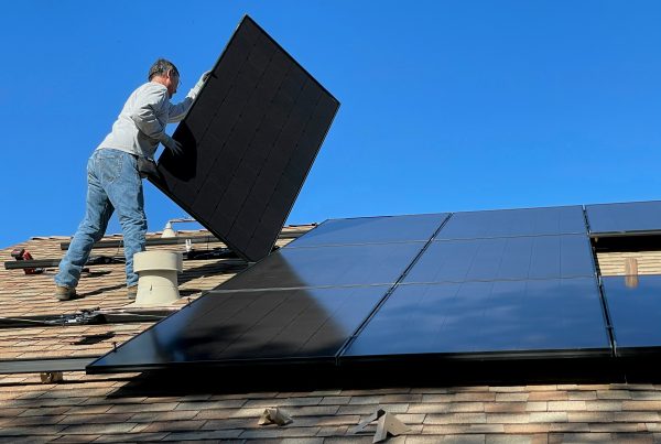 Engineer placing a solar panel on a roof