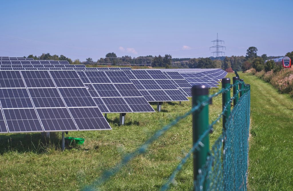 rows of solar panels standing in a field.