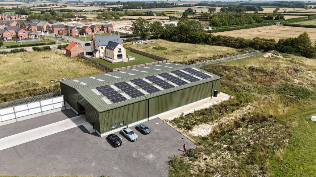 view of solar panels on a warehouse near village